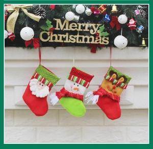 Three hanging Christmas stockings with Santa, Snowman, and Reindeer designs on a fireplace