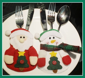 Detailed top view of Santa and snowman cutlery holders placed on a white ceramic plate