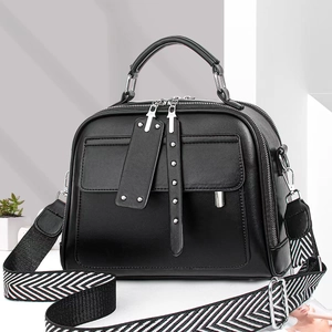Detail van zwarte PU-leren tas met dubbele ritsen en een geweven stoffen schouderband