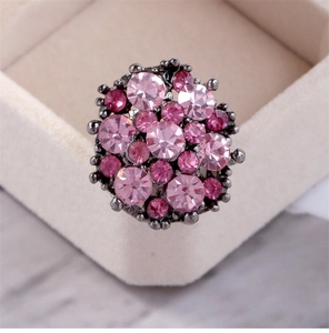 Macro shot of pink crystal floral ring cluster with gunmetal finish on a jewelry box