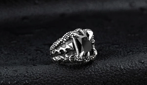 Close-up of vintage steel ring featuring a dragon claw design and black zircon gemstone