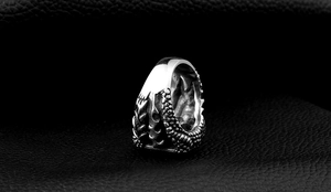 Macro shot of stainless steel men's ring featuring detailed dragon claw scale texture