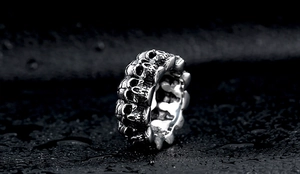 Macro shot of punk style stainless steel skull ring with embossed gothic texture