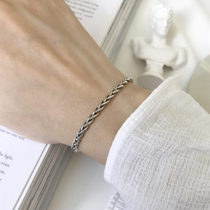 Close-up of S925 sterling silver braided twist bracelet worn on wrist in vintage style