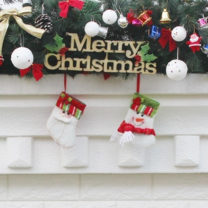 Christmas stockings and gold Merry Christmas sign displayed on a white brick fireplace