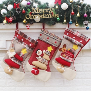 Three Christmas stockings with Santa, snowman and reindeer hanging on fireplace