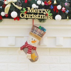 Chaussette de Noël à carreaux avec motif bonhomme de neige sur une cheminée blanche décorée