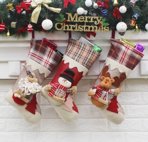 Three Christmas stockings with Santa, Snowman and Reindeer hanging on a fireplace