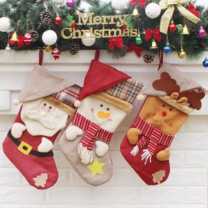 Trois chaussettes de Noël festives avec Père Noël, bonhomme de neige et renne sur cheminée