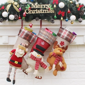 Détail de chaussettes de Noël avec Père Noël, bonhomme de neige et renne sur la cheminée