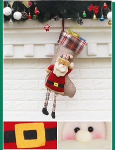 Détail d'une peluche de Père Noël sur une chaussette de Noël en lin avec carreaux
