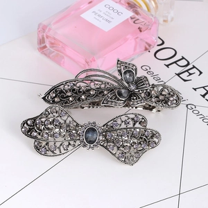 Close-up of vintage alloy hair clips with gray crystals and butterfly design detail