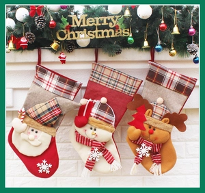 Three festive Christmas stockings with Santa, Snowman and Reindeer on a mantel decoration
