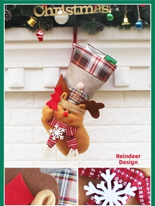 Detail of burlap Christmas stocking with 3D elk doll and festive plaid trim hanging on wall