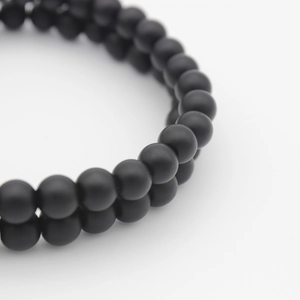 Close-up of double-layer beaded bracelet featuring matte black stones on white background