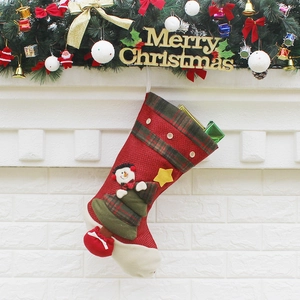 Classic plaid Christmas stocking with snowman and tree hanging on a festive fireplace
