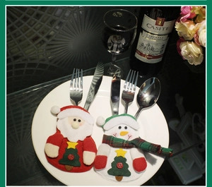 Detail of Santa and Snowman cutlery holders on a ceramic plate for Christmas table setting