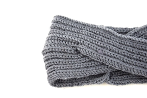 Dettaglio macro della trama in maglia grigio scuro e nodo intrecciato sulla fascia