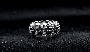 Macro shot of gothic punk skull rings with oxidized silver finish and detailed 3D carving