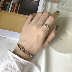 Close-up of S925 sterling silver knotted ring and bracelet set on a hand