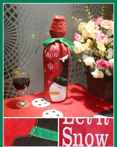 Detail showing red snowman embroidery and Let it Snow text on a wine bottle cover