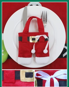 Detail of Santa pants cutlery holder with velvet texture, gold buckle, and white plush trim