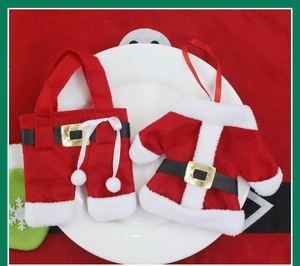 Detail of Christmas cutlery holder set with red clothes and pants on white plate