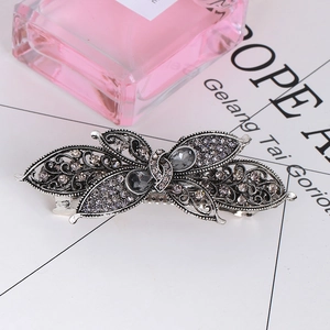 Detailed view of a vintage silver butterfly hair clip with grey crystal rhinestones