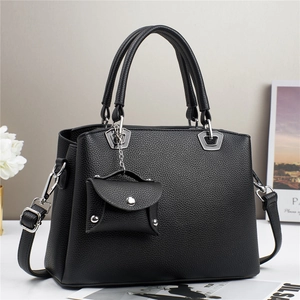 Dettaglio borsa a mano in pelle martellata nera con finiture argentate e mini pouch