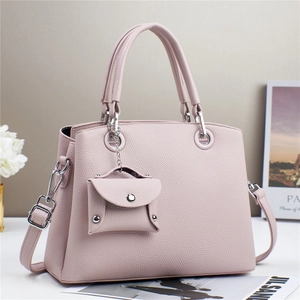 Dettaglio borsa a mano in pelle litchi rosa con accessori argento e mini bustina