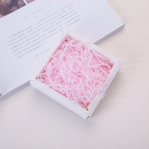 Pink shredded raffia paper filler in white gift box for packaging decoration