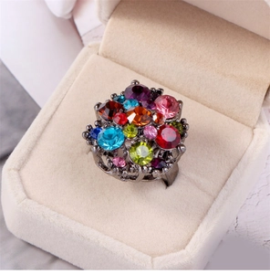 Detail shot of multi-colored gemstones in a vintage cluster ring on velvet