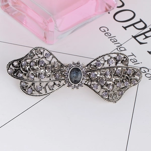 Detail of vintage silver butterfly hair clip with grey crystals and blue gemstone