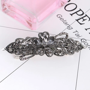 Detail of vintage silver hair clip featuring intricate filigree and crystal embellishments