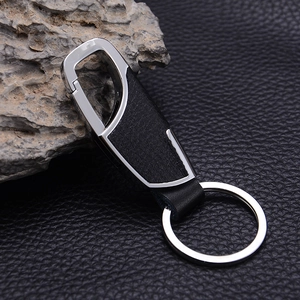 Sleek metal and black leather keychain with spring clip on dark textured background