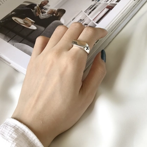 Detail of vintage silver ring with black cross engraving on a model finger