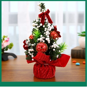 Close-up of 20cm mini Christmas tree with red bows and white berries on a wooden desk