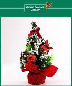 Detailed view of mini 20cm Christmas tree with red ribbons and golden berries decoration