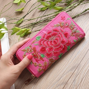 Close-up of pink long fabric wallet featuring detailed peony floral embroidery and zipper
