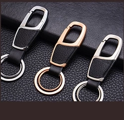 Macro shot of three luxury leather keychains in silver, rose gold, and gunmetal finishes