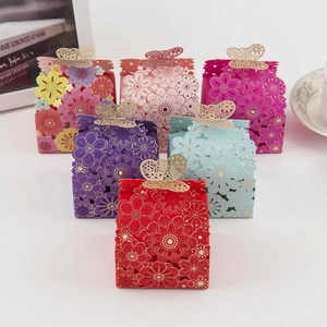 Detail of laser-cut butterfly wedding favor boxes with elegant hollow floral patterns
