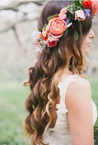 Detail of bohemian bridal flower crown with orange roses and pink silk blossoms on white lace