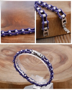 Detail of purple and silver stainless steel motorcycle chain bracelet on a wooden stand
