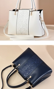 Detailed close-up of white and navy handbags with embroidery and pearl zipper pullers
