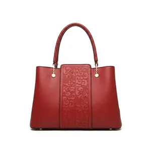 Macro detail of dark red cowhide leather with cloud pattern and metal handle