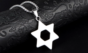 Detailed close-up of a silver hexagram pendant on dark textured leather background