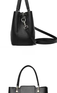 Detail view of black leather bucket bag with gold hardware and elegant pearl charm