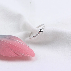 Minimalist 925 sterling silver beaded open ring on soft fabric with feather accent