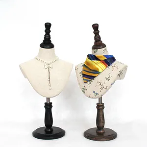 Detail view of velvet neck mannequins in beige fabric and floral patterns for jewelry display