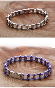 Detail view of silver and purple industrial bicycle chain bracelets on wooden background